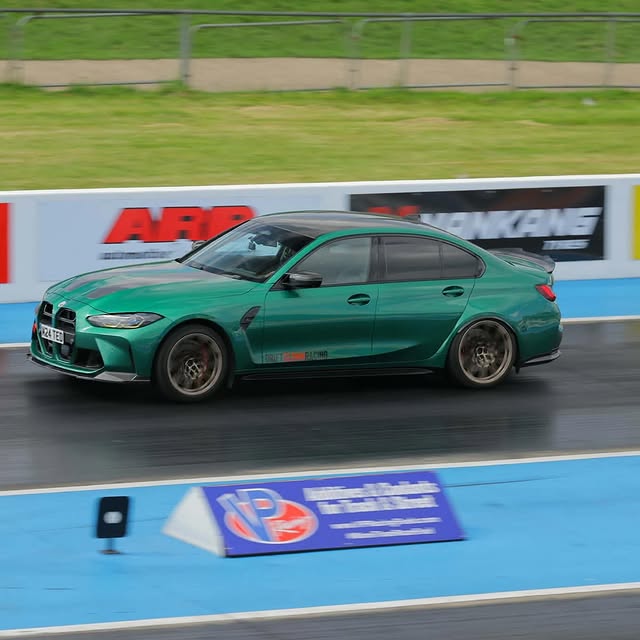 Green BMW launching down the drag strip